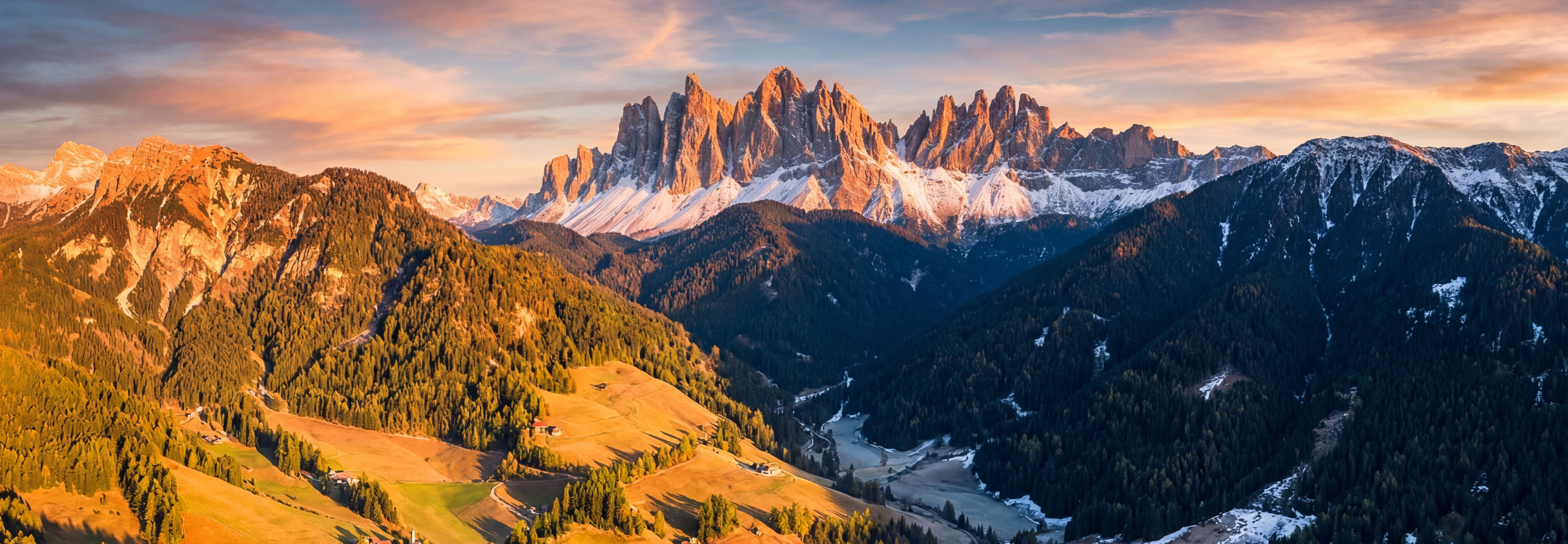 Aerial view of dramatic mountain shadows across a valley at golden hour
